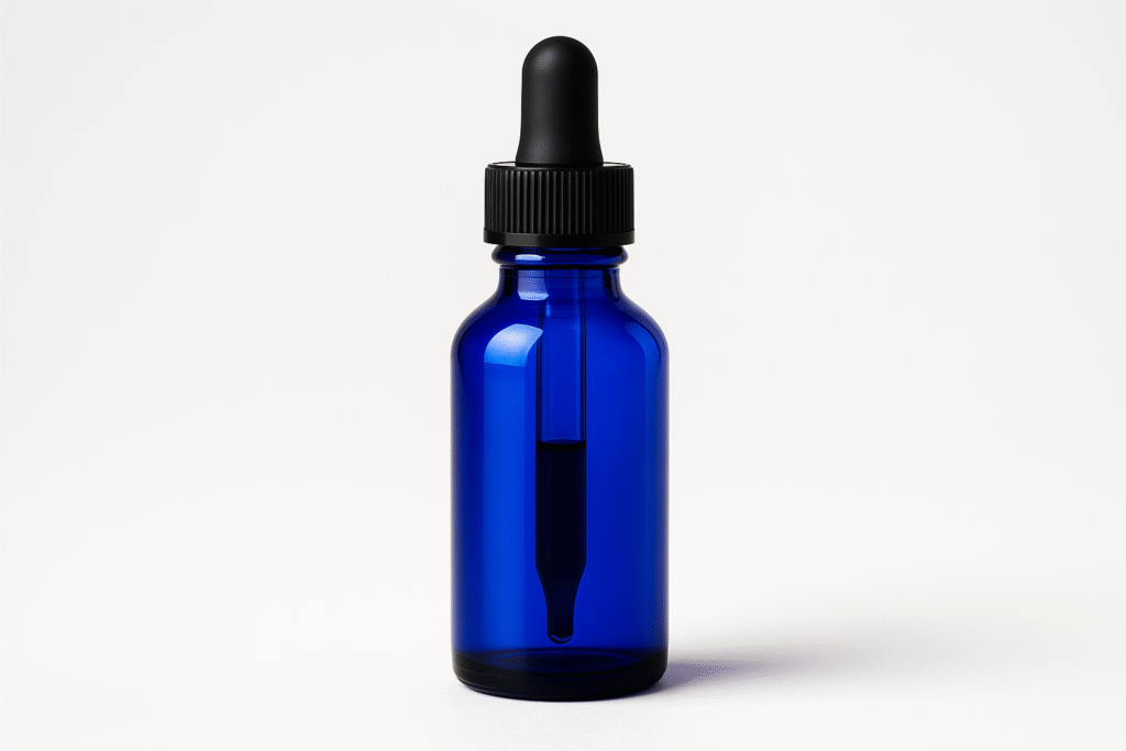 A cobalt-blue glass dropper bottle filled with liquid on a clean white surface, representing methylene blue supplement used for energy and brain health.